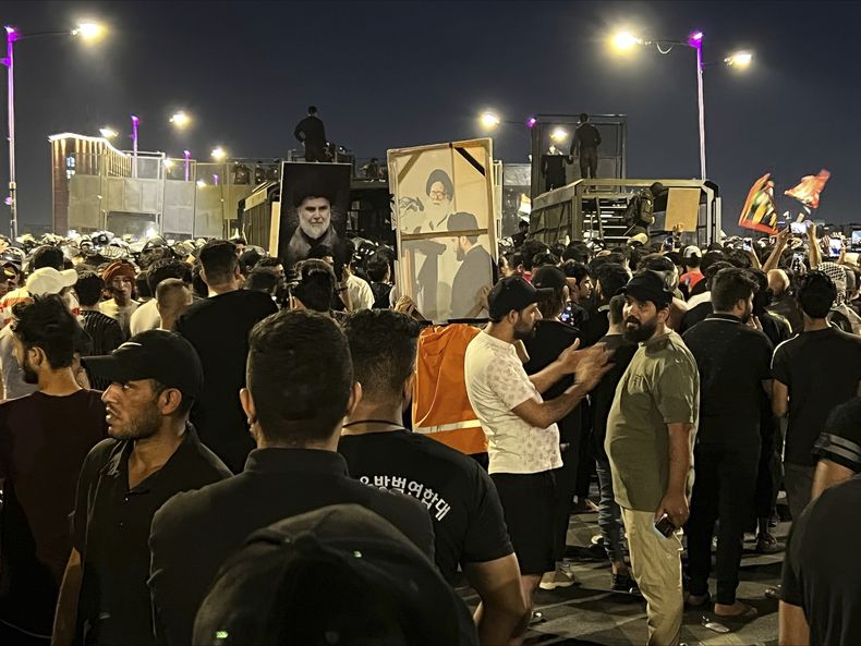 Manifestantes se congregan en la plaza Tahrir de Bagdad con banderas iraquíes e imágenes del influyente clérigo chií y líder político iraquí Muqtada al-Sadr, el 22 de julio de 2023, luego de los reportes de quema de un Corán por parte de un grupo ultranacionalista ante la embajada de Irak en Copenhague. (AP Foto/Ali Jabar)