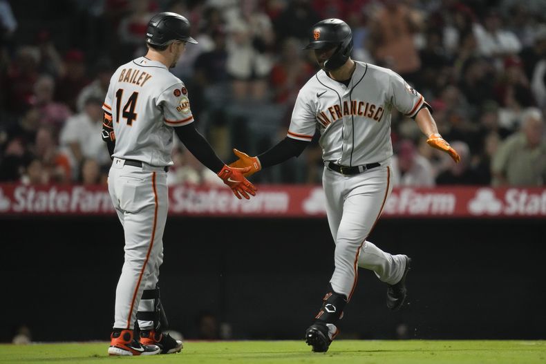 J.D. Davis de los Gigantes de San Francisco celebra con Patrick Bailey tras pegar un jonrón en la séptima entrada del encuentro ante los Angelinos de Los Ángeles el lunes 7 de agosto del 2023. (AP Foto/Ashley Landis)