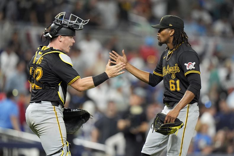 El receptor de los Piratas de Pittsburgh, Henry Davis (32), y el relevista José Hernández (61), se felicitan después de que los Piratas vencieron 6-5 a los Marlins de Miami en 12 entradas del juego de béisbol, el jueves 28 de marzo de 2024, en Miami. (AP Foto/Wilfredo Lee)
