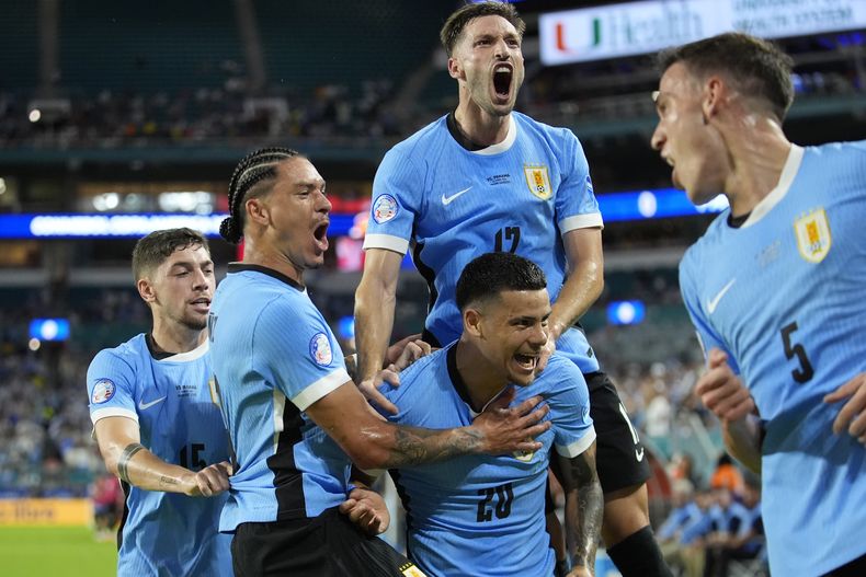 Maximiliano Araújo (abajo en el centro) celebra tras un gol para Uruguay en el partido contra Panamá por el Grupo C de la Copa AMérica, el domingo 23 de junio de 2024, en Miami Gardens, Florida. (AP Foto/Rebecca Blackwell)