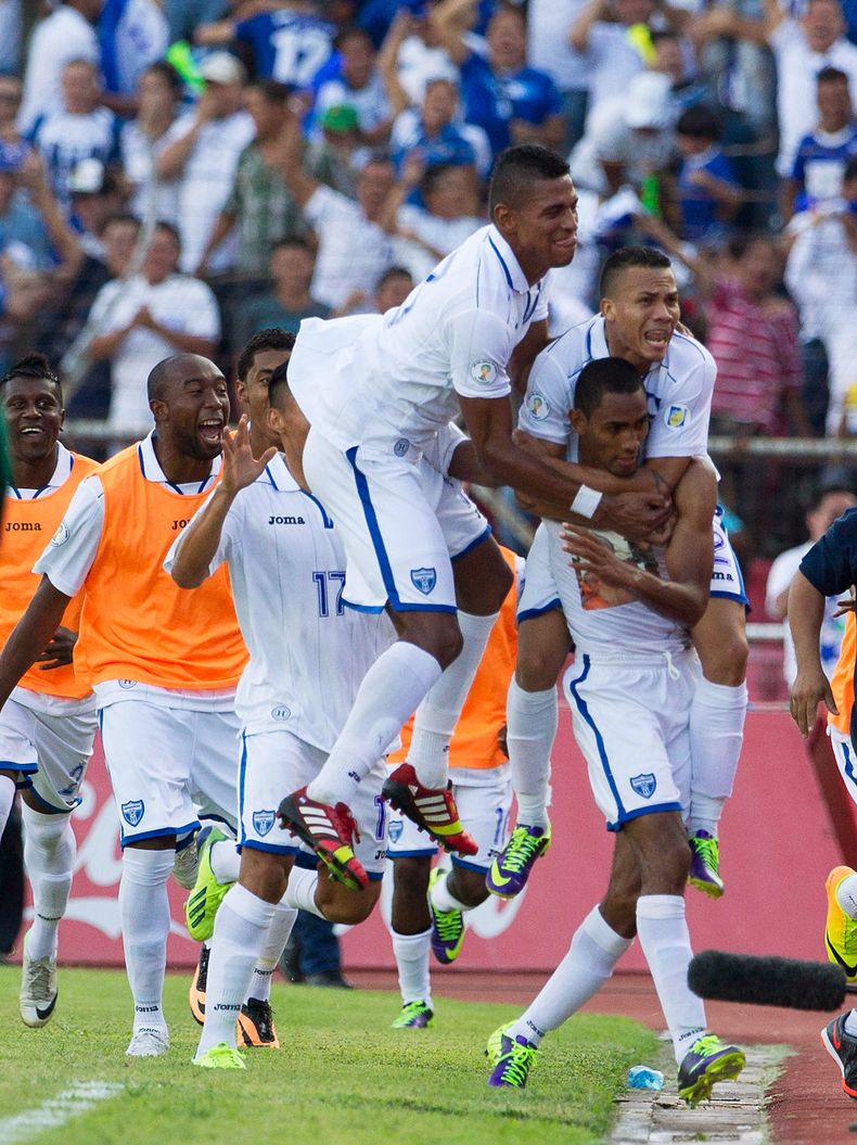 Los jugadores de Honduras abrazan a Jerry Bengtson, autor del gol que le dio al equipo catracho una victoria 1-0 sobre Costa Rica y lo dej&oacute; a un paso de la Copa Mundial del 2014 el 11 de octubre del 2013 en San Padro Sula, Honduras. (AP Photo/Mois&