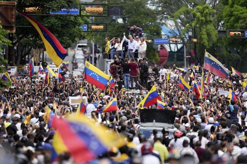 La líder opositora María Corina Machado y el candidato opositor Edmundo González viajan encima de un camión durante una protesta contra los resultados oficiales de las elecciones presidenciales que declaran ganador al presidente Nicolás Maduro en Caracas, Venezuela, el martes 30 de julio de 2024, dos días después de la votación. (AP Photo/MatÍas Delacroix)
