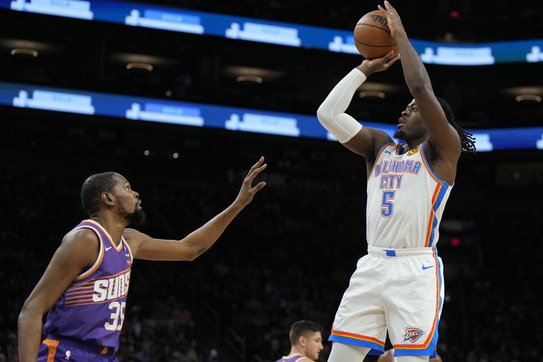Luguentz Dort, del Thunder de Oklahoma Ciy, dispara frente a Kevin Durant (35), de los Suns de Phoenix, durante la primera mitad del juego de baloncesto de la NBA, el domingo 3 de marzo de 2024, en Phoenix. (AP Foto/Rick Scuteri)