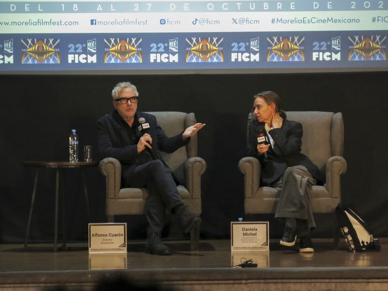 El director Alfonso Cuarón, izquierda, habla durante una charla con la directora general del Festival Internacional de Cine de Morelia, Daniela Michel, en el Festival Internacional de Cine de Morelia, el jueves 24 de octubre de 2024, en Morelia, México. (Foto AP/Berenice Bautista)