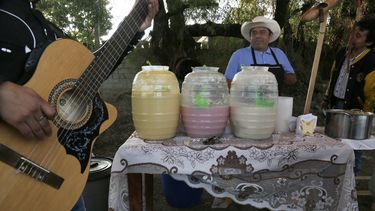 ARCHIVO - Un músico afina su guitarra mientras un vendedor de pulque espera clientes en Santiago Cuautlalpan, México, el 20 de noviembre de 2016. Cuba y México tienen otro punto en común entre con la inscripción binacional del bolero en la Lista Representativa del Patrimonio Cultural Inmaterial de la Unesco celebrada el 5 de diciembre de 2023. (Foto AP/Marco Ugarte, archivo)