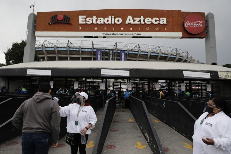 ARCHIVO - Un aficionado se somete a una revisión de su temperatura al ingresar al estadio Azteca de Ciudad de México antes de un partido entre Cruz Azul y Toluca, el 15 de mayo de 2021 (AP Foto/Eduardo Verdugo, archivo)
