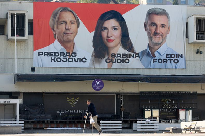 Un hombre camina bajo un cartel electoral que muestra a los candidatos Nuestro Partido (NS) para las próximas elecciones generales en Sarajevo, Bosnia, el 29 de septiembre 2026. (AP Foto/Armin Durgut)