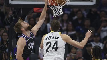 Domantas Sabonis, izquierda, de los Kings de Sacramento, clava el balón superando a Walker Kessler (24), del Jazz de utah, durante la primera mitad del juego de baloncesto de la NBA, el domingo 31 de marzo de 2024, en Sacramento, California. (AP Foto/Randall Benton)