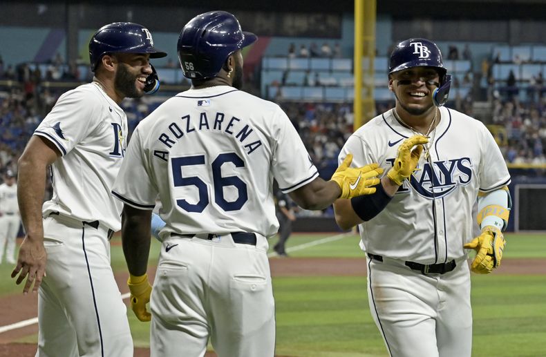 El mexicano Isaac Paredes (derecha), de los Rays de Tampa Bay, festeja con Amed Rosario y Randy Arozarena luego de pegar un jonrón de t res carreras ante los Yankees de Nueva York, el martes 9 de julio de 2024 (AP Foto/Steve Nesius)