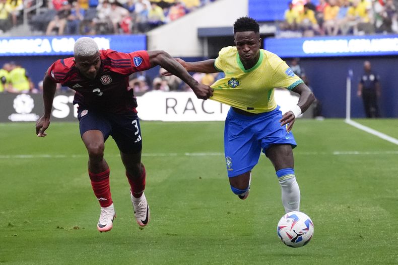 El costarricense Jeyland Mitchell (izquierda) jala la camiseta del brasileño Vinicius Júnior en el partido por el Grupo D de la Copa América, el lunes 24 de junio, en Inglewood, California. (AP Foto/Mark J. Terrill)