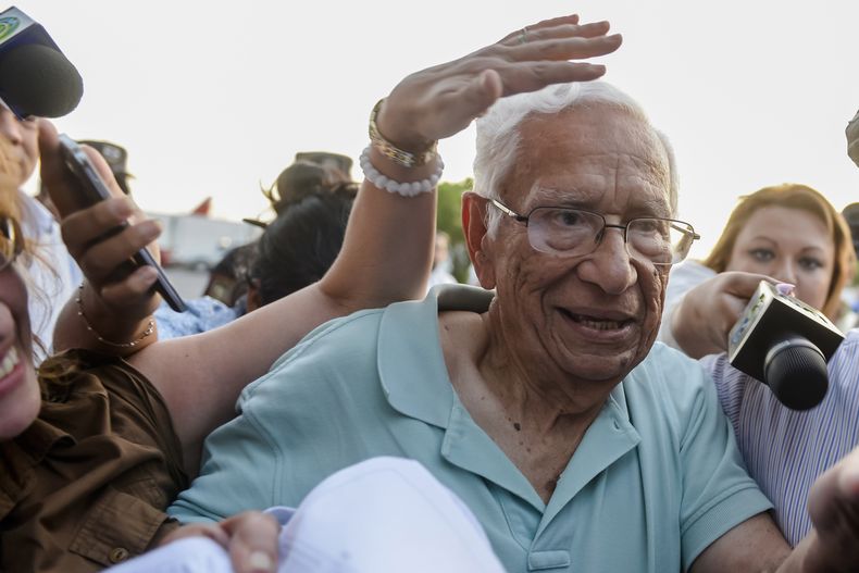 ARCHIVO - El exministro de Defensa José Guillermo García es rodeado por la prensa a su llegada al aeropuerto internacional Oscar Arnulfo Romero en San Luis Talpa, El Salvador, el 8 de enero de 2016. (Foto AP/Salvador Meléndez, Archivo)