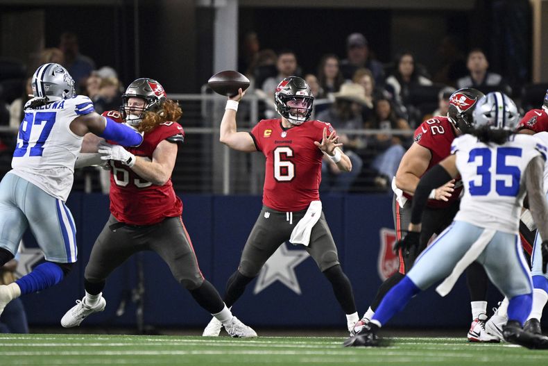 El quarterback de los Buccaneers de Tampa Bay Baker Mayfield lanza el balón frente a la presión de Osa Odighizuwan y Marist Liufau de los Cowboys de Dallas el domingo 22 de diciembre del 2024. (AP Foto/Jerome Miron)