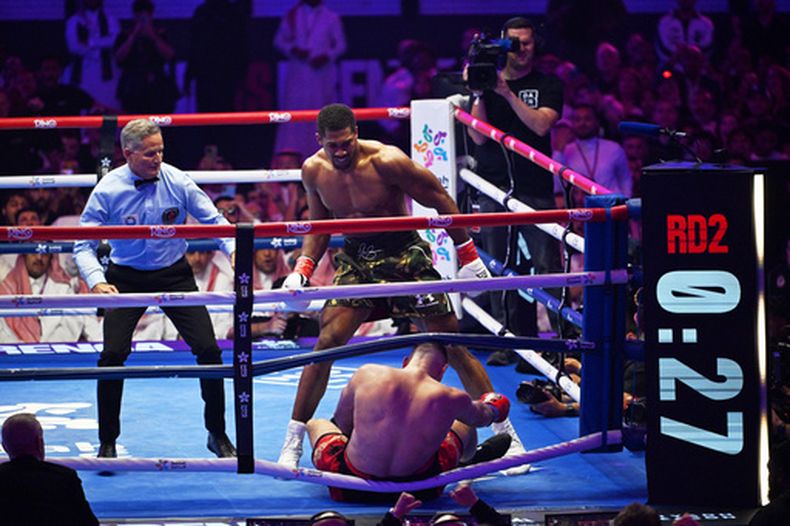 El británico Anthony Joshua derriba al albanés Kristian Prenga durante su pelea dentro de la división de los pesados en Yeda, Arabia Saudí, el dominbo 26 de julio de 2026 (AP Foto/Ali Issa)