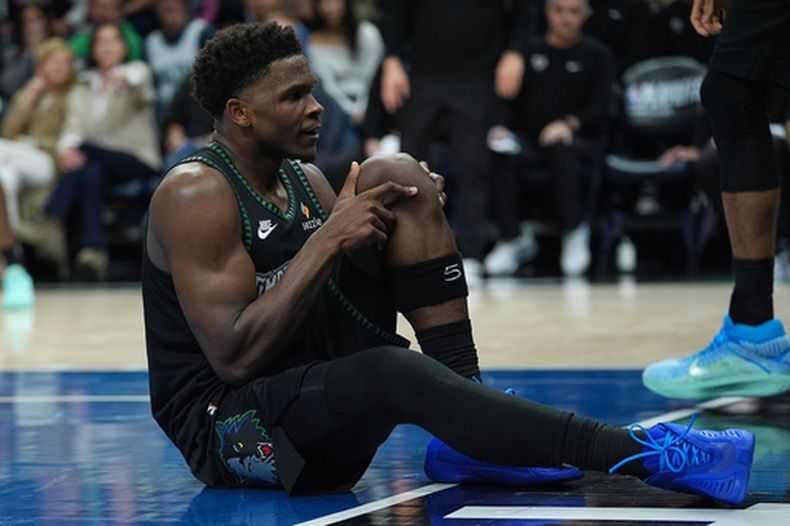 El base de los Timberwolves de Minnesota Anthony Edwards se toma la rodilla tras lesionarse en el juego 4 de la primera ronda de los playoffs ante los Nuggets de Denver el sábado 25 de abril del 2026. (AP Foto/Abbie Parr)