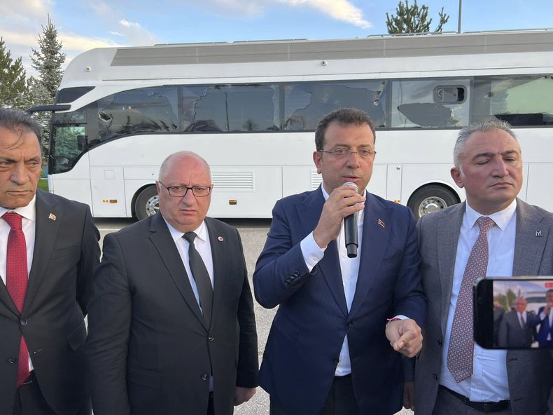 En esta imagen proporcionada por el Partido Popular Republicano (CHP) de Turquía, el alcalde de Estambul e integrante del CHP, Ekrem Imamoglu, segundo de derecha a izquierda, se dirige a sus partidarios delante de su autobús de campaña durante un acto en Erzurum, Turquía, el domingo 7 de mayo de 2023. (CHP vía AP)