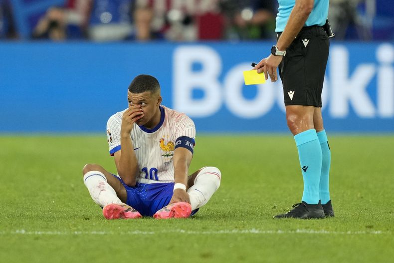 El atacante francés Kylian Mbappé en el piso con la nariz sangrando al ser amonestado en el partido contra Austria por el Grupo D de la Eurocopa, el lunes 17 de junio de 2024. (AP Foto/Andreea Alexandru)