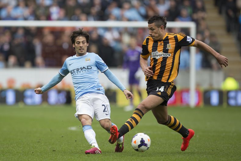 El delantero de Manchester City David Silva, izq., disputa la pelota con el defensor de Hull city, Jake Livermore, en partido de la Liga Premier en Hull el s&aacute;bado 15 de marzo del 2014. Silva anot&oacute; uno de los goles con que su equipo gan&oacut