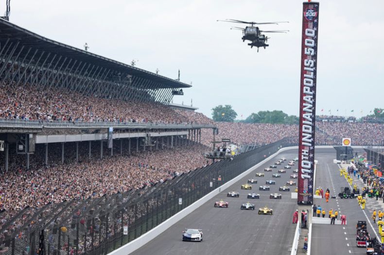 Helicopters sobrevuelan el Motor Speedway en Indianapolis antes de las 500 Millas de Indianápolis el domingo 24 de mayo del 2026. (AP Foto/Michael Conroy)