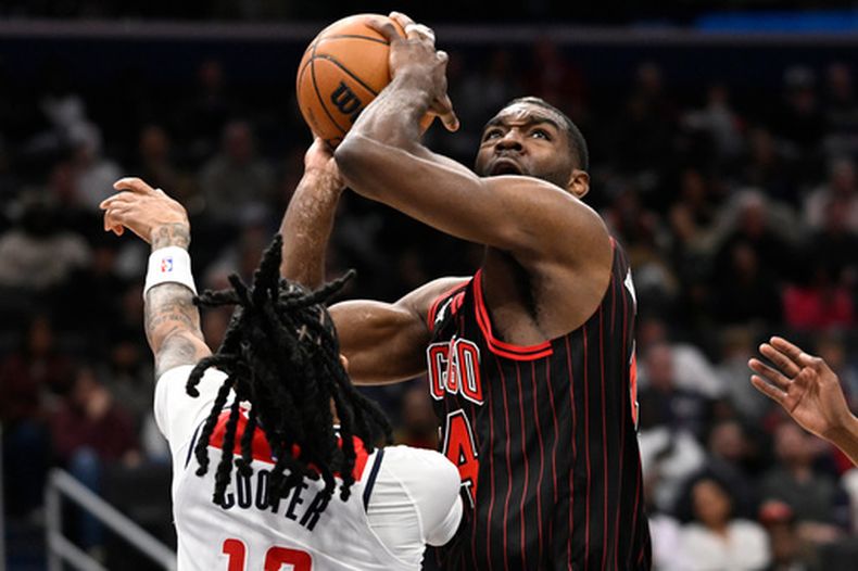 Patrick Williams, alero de los Bulls de Chicago, dispara frente a Sharife Cooper, de los Wizards de Washington, en el partido del martes 7 de abril de 2026 (AP Foto/John McDonnell)