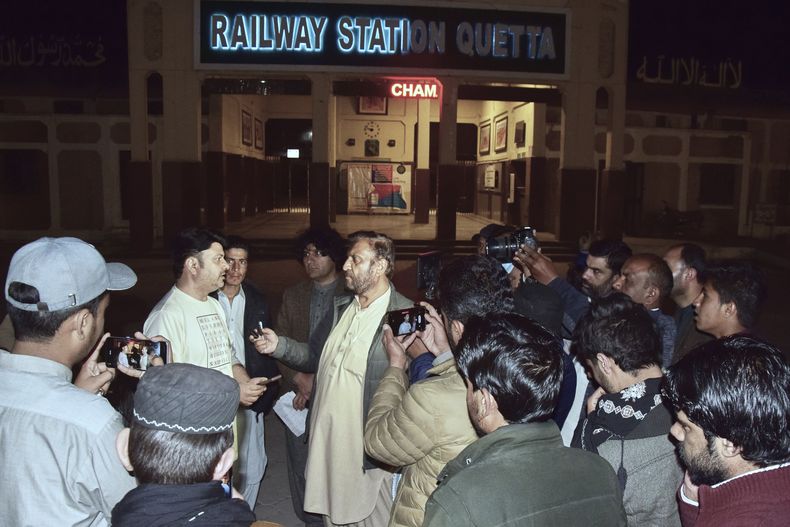 Familiares de los pasajeros de un tren atacado por insurgentes se congregan frente a una mesa especial para obtener información sobre sus seres queridos en una estación de tren en Quetta, Pakistán, el martes 11 de marzo de 2025. (AP Foto/Arshad Butt)