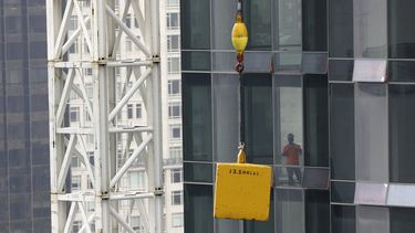 americateve | Un hombre observa una carga atorada que qued&oacute; suspendida sobre una calle de la ciudad de Nueva York, el lunes 7 de octubre de  2013. (Foto AP/Seth Wenig)