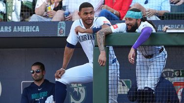 El bateador designado de los Marineros de Seattle, Julio Rodríguez, y J.P. Crawford conversan en el barandal de la banca durante la segunda entrada de un partido de béisbol contra los Gigantes de San Francisco, el sábado 18 de julio de 2026, en Seattle. (Foto AP/Lindsey Wasson)