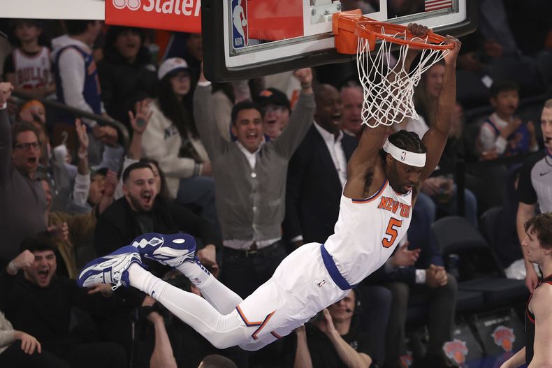 Precious Achiwa, de los Knicks de Nueva York, cuelga del aro tras realizar una clavada en el encuentro ante los Bulls de Chicago, el jueves 20 de febrero de 2025 (AP Foto/Pamela Smith)