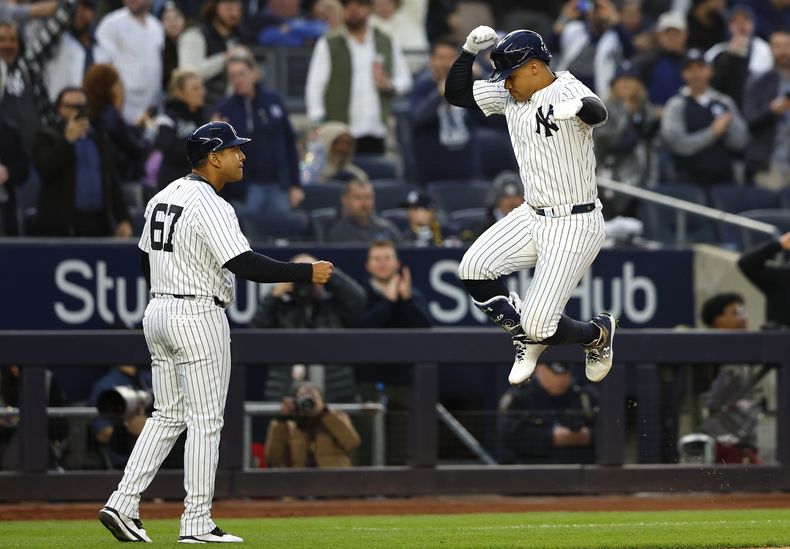 Juan Soto, derecha, de los Yankees de Nueva York, reacciona frente al coach de tercera, Luis Rojas (67), después de conectar jonrón contra los Marlins de Miami durante la cuarta entrada del juego de béisbol, el lunes 8 de abril de 2024, en Nueva York. (AP Foto/Noah K. Murray)