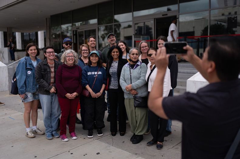 Masuma Khan, segunda desde la derecha en la primera fila, y su hija Riya, cuarta desde la derecha en la primera fila, posan con sus simpatizantes tras una cita en el edificio federal de Los Ángeles, el 21 de abril de 2026. (Foto AP/Jae C. Hong)