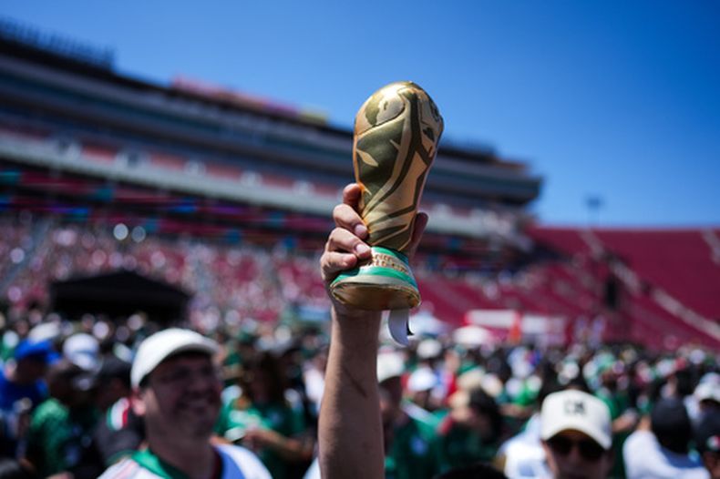 Un aficionado sostien una réplica del Mundial en un fan fest en el Coliseo Memorial de Los Ángeles, el jueves 11 de junio de 2026. (AP Foto/Jae C. Hong)