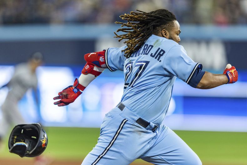 Vladimir Guerrero Jr., bateador designado de los Azulejos de Toronto, bateó rola para decisión del jugador de cuadro, que impulsó la carrera de Cavan Biggio en un error, durante la quinta entrada del juego de béisbol en contra de los Mellizos de Minnesota, en Toronto, el domingo 11 de junio de 2023. (Mathew Tsang/The Canadian Press vía AP)