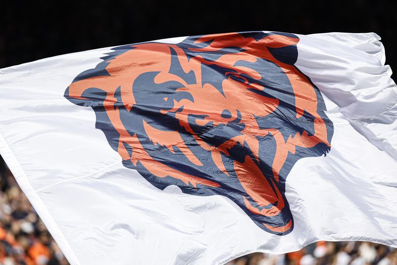 ARCHIVO - El logotipo de los Bears de Chicago se despliega en una bandera previo al partido de la NFL entre los Bears y los Broncos de Denver, el 1 de octubre de 2023. Los Bears programaron una conferencia de prensa el miércoles 24 de abril de 2024 para anunciar los planes de un un estadio cerrado de propiedad pública y de última generación con acceso a la orilla del Lago Michigan. (AP Foto/Kamil Krzaczynski, Archivo)