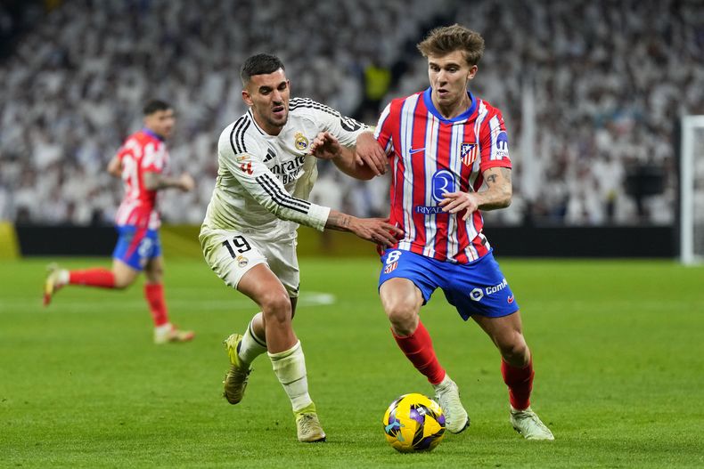 Dani Ceballos del Real Madrid pelea por el balón con Pablo Barrios del Atlético de Madrid en el derbi de la liga española el sábado 8 de febrero del 2025. (AP Foto/Manu Fernandez)