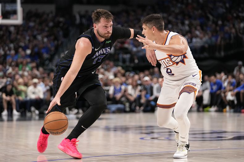 Luka Doncic, de los Mavericks de Dallas a la izquierda, se enfrenta al escolta de los Suns de Phoenix, Grayson Allen (8), en la segunda mitad del partido de baloncesto de la NBA en Dallas, el jueves 22 de febrero de 2024. (AP Foto/Tony Gutiérrez)