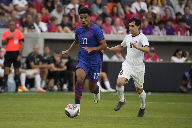 En foto del sábado 9 de septiembre del 2023, el estadounidense Malik Tillman avanza con el balón frente a Jamshid Iskanderov de Uzbekistán en el encuentro amistoso. (AP Foto/Jeff Roberson)