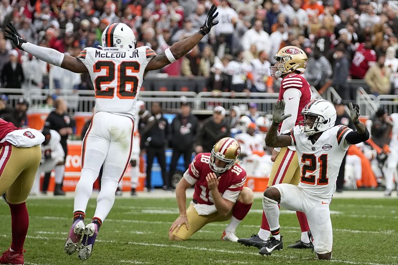 Jake Moody, arriba a la derecha, y Mitch Wishnowsky (18) reaccionan mientras que Rodney McLeod Jr. (26) y Denzel Ward (21), de los Browns de Cleveland, celebran después de que Moody fallara un gol de campo al final del partido de la NFL, el domingo 15 de octubre de 2023, en Cleveland. (AP Foto/Sue Ogrocki)