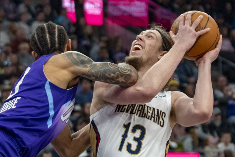 El alero de los Pelicans de Nueva Orleans, Kelly Olynyk (13), choca con el escolta del Jazz de Utah, Keyonte George, a la izquierda, durante la primera mitad de un partido de baloncesto de la NBA, el domingo 2 de marzo de 2025, en Salt Lake City. (AP Foto/Rick Egan)
