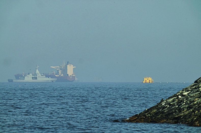 Una patrullera emiratí (izquieda), navega cerca de un petrolero fondeado en el golfo de Omán, cerca del estrecho de Ormuz, vistos desde una carretera costera cerca de Khor Fakkan, Emiratos Árabes Unidos, el 1 de mayo de 2026. (AP Foto/Fatima Shbair)