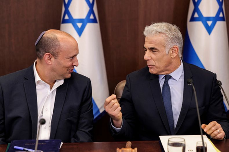 El entonces primer ministro israelí Yair Lapid (d) con el ex primer ministro Naftali Bennett en una reunión de gabinete en Jerusalén, el 18 de septiembre del 2022. (Ronaldo Schemidt/Pool Photo via AP)
