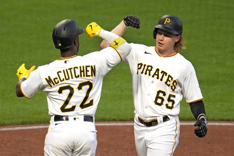 Jack Suwinski de los Piratas de Pittsburgh celebra con Andrew McCutchen trar cruzar el plato tras pegar su jonrón de dos carreras en la cuarta entrada del encuentro ante los Cerveceros de Milwaukee el lunes 4 de septiembre del 2023. (AP Foto/Gene J. Puskar)