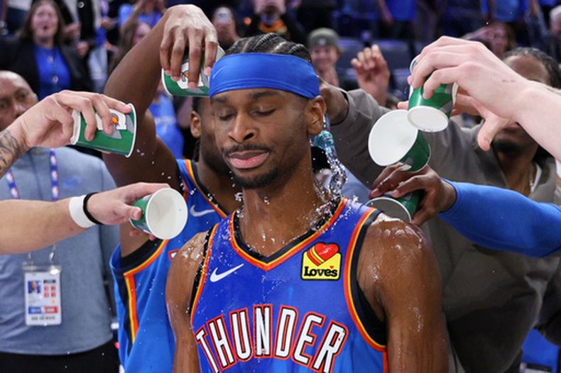 Jugadores del Thunder de Oklahoma City vierten vasos con agua sobre Shai Gilgeous-Alexander después del juego de baloncesto de la NBA contra los Celtics de Boston, el jueves 12 de marzo de 2026, en Oklahoma City. (AP Foto/Nate Billings)