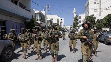 americateve | Soldados israel&iacute;es patrullan las calles de un pueblo cercano a Cisjordania en busca de los tres j&oacute;venes presuntamente secuestrados el mi&eacute;rcoles 18 de junio de 2014.  (AP Photo/Majdi Mohammed)