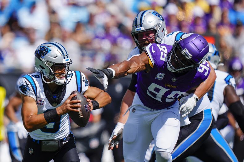 Bryce Young, quarterback de los Panthers de Carolina, busca un receptor en lo que intenta quitarse la presión de un defensivo de los Vikings de Minnesota, durante la primera mitad del partido de la NFL, el domingo 1 de octubre de 2023, en Charlotte, Carolina del Norte. (AP Foto/Jacob Kupferman)