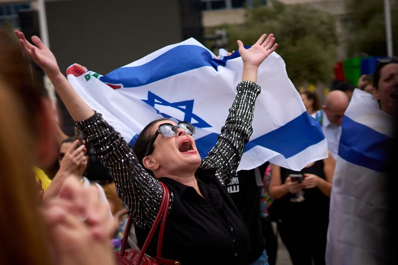 Una mujer extiende los brazos tras el anuncio de que Israel y Hamás han llegado a un acuerdo sobre la primera fase de un plan de paz para detener los combates, el jueves 9 de octubre de 2025, en lo que se conoce como la plaza de los Rehenes en Tel Aviv, Israel. (AP Foto/Emilio Morenatti)