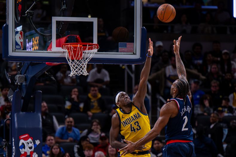 Kawhi Leonard, de los Clippers de Los Ángeles, dispara frente a Pascal Siakam, de los Pacers de Indiana, en el partido del viernes 27 de marzo de 2026 (AP Foto/Doug McSchooler)