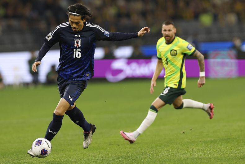 Koki Machida de Japón, izquierda, supera a Martin Boyle de Australia durante su partido de fútbol de clasificación para la Copa del Mundo 2026, grupo C, en Perth, el jueves 5 de junio de 2025. (AP Photo/Trevor Collens)