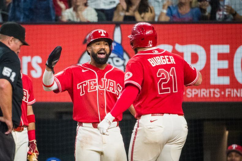 Jake Burger, de los Rangers de Texas, festeja con el dominicano Ezequiel Durán durante el encuentro ante los Marineros de Seattle, el viernes 24 de julio de 2026 (AP Foto/Jessica Tobias)