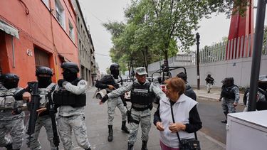 La Guardia Nacional retira a un peatón de los alrededores de la sede de la Fiscalía General en Ciudad de México, el domingo 22 de febrero de 2026, tras la muerte del líder del Cártel Jalisco Nueva Generación, Nemesio Oseguera Cervantes, conocido como El Mencho (Foto AP/Ginette Riquelme)