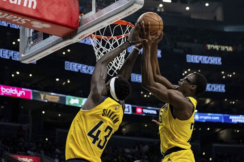 Jalen Smith, derecha, y Pascal Siakam (43), de los Pacers de Indiana, buscan un rebote durante la segunda mitad del juego de baloncesto de la NBA en contra de los Clippers de Los Ángeles, el lunes 25 de marzo de 2024, en Los Ángeles. (AP Foto/William Liang)