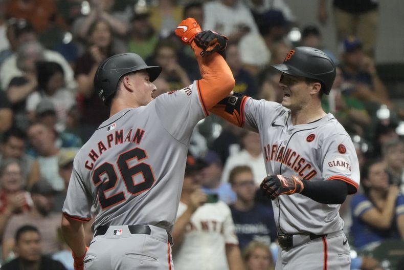 Mike Yastrzemski, de los Gigantes de San Francisco, es felicitado por su compañero Matt Chapman, luego de batear un jonrón de dos carreras en el encuentro del martes 27 de agosto de 2024, ante los Cerveceros de Milwaukee (AP Foto/Morry Gash)